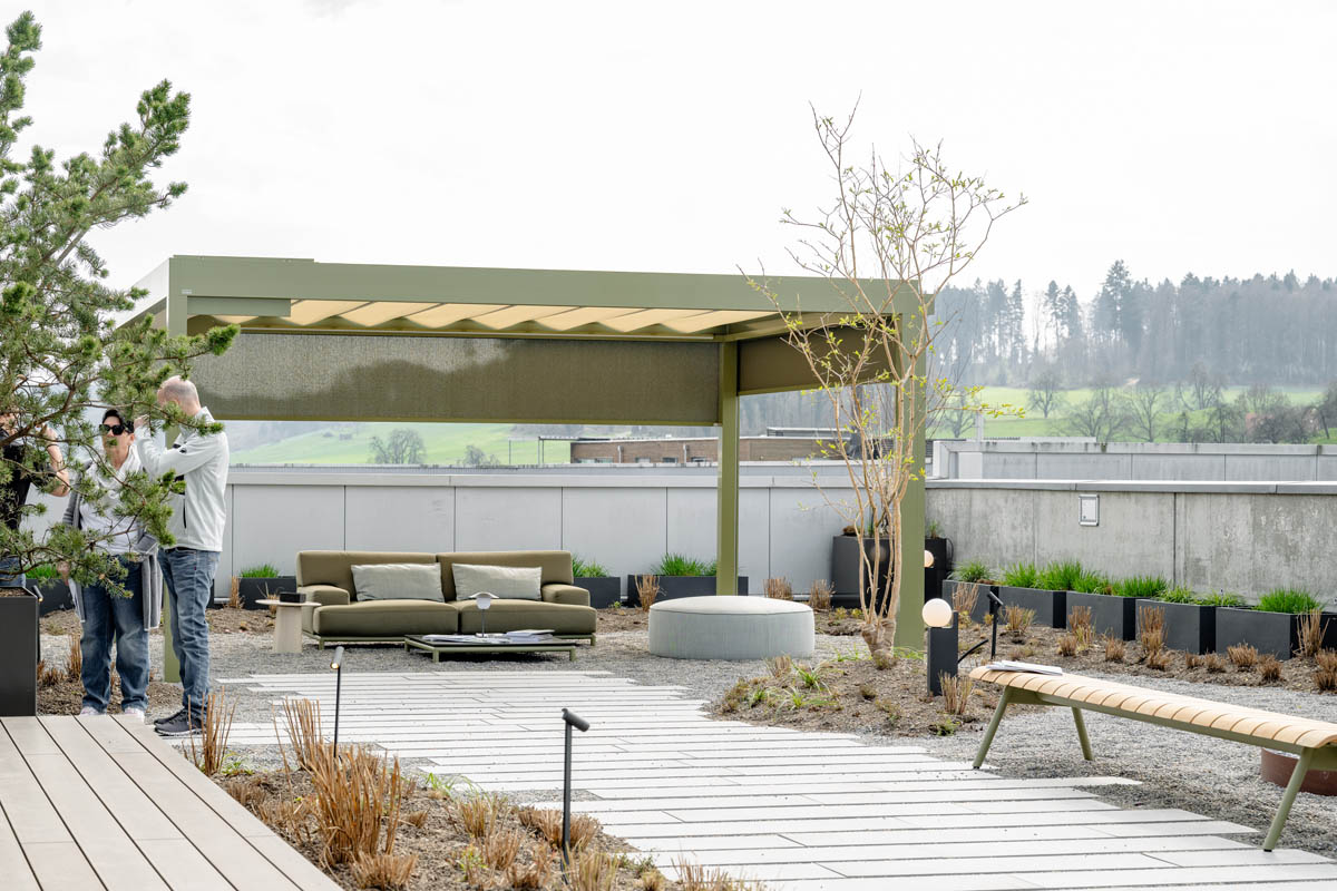Dachterasse mit Personen und Metallpergola